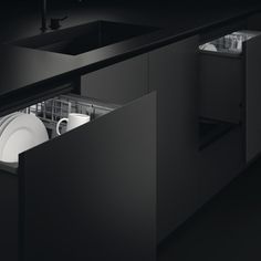 an open dishwasher in a black kitchen