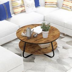 a living room filled with white couches and pillows on top of a rug next to a coffee table