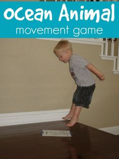 a young boy standing on top of a wooden floor next to an ocean animal game