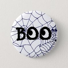 a button with the word boo written on it in black and white spider web pattern