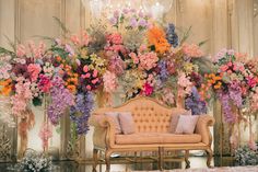 a couch sitting in front of a bunch of flowers