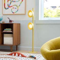 a child's room with toys on the floor, and a yellow lamp in the corner