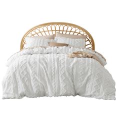 a bed with white comforter and pillows on it's headboard, in front of a white background