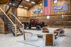 an old truck is parked in a large building with stairs and seating area for people to sit on