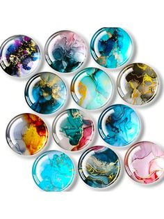 twelve glass cabochons with different colors and designs on them, arranged in the shape of a circle