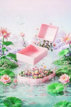 two pink boxes floating on top of water surrounded by flowers