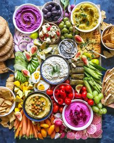 a table topped with lots of different types of food and dips on top of it