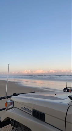 a white truck parked on top of a sandy beach