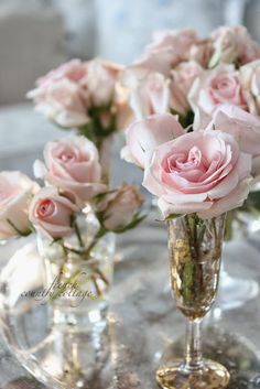 some pink roses are in vases on a table