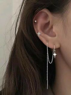 a woman wearing silver ear chains with stars on the back of her ear and one star dangling