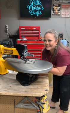 a woman standing next to a table with a metal object on it