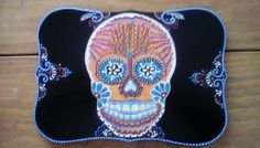 a colorfully painted sugar skull sits on a wooden surface