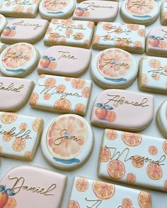 many decorated cookies with writing on them are arranged in the shape of oranges and grapefruits