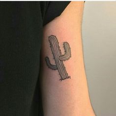 a small cactus tattoo on the arm