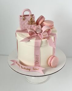 a birthday cake decorated with pink and gold decorations on a white platter that says, do it