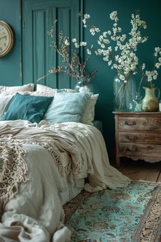 a bedroom with teal walls and white flowers in vases