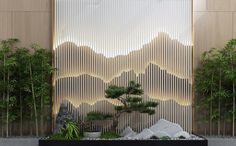 an indoor garden with trees and rocks in front of a wall that has mountains on it