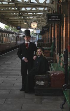 two people standing next to each other on a train platform