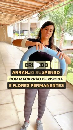 a woman holding a baseball bat in front of her face with the caption arranjo sustenso com macararo de pisica e flores permanentes permanientes