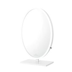 a round mirror on a stand with a white surface in front of a white background