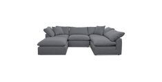 a gray sectional couch with pillows on it's back and the seat facing outward