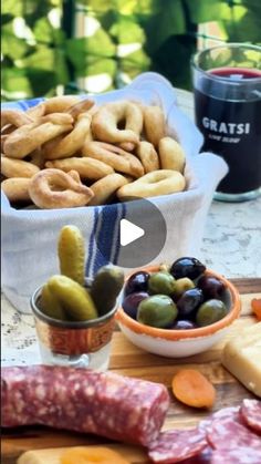 an assortment of cheeses, olives, and meats on a cutting board