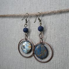 Beautiful Navy Sphere Bead That Is Splattered With Bronze Accent And Surrounded By A Bronze Hoop Topped With A Navy Bead. The French Hook Earrings Are Nickle Free Surgical Steel With A 3 Inch Length And 1.25 Inch Width. Blue Beaded Metal Hoop Earrings, Blue Metal Jewelry, Blue Round Beaded Metal Earrings, French Hook Earrings, Artisan Earrings, Wrapped Jewelry, Earrings Color, Hook Earrings, Wire Wrapped Jewelry