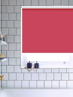 a bathroom with red roller shades in the window and white tiles on the wall behind it