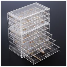 a stack of clear drawers sitting on top of a black table