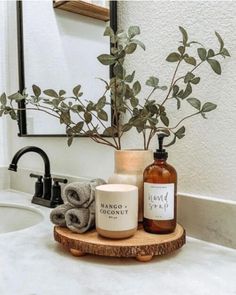 a bathroom sink with soap, hand sanitizer and towels on it in front of a mirror