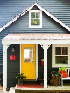 a yellow front door on a gray house