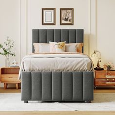 a bed with grey upholstered headboard and foot board in a white room