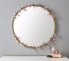 a mirror that is sitting on top of a table next to a brush and toothbrush