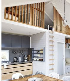 an open kitchen and dining room area with stairs leading up to the loft above it