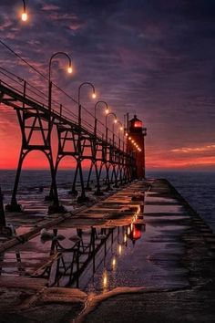 a pier with lights reflecting in the water