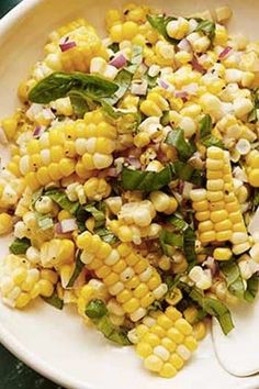 a white bowl filled with corn and vegetables