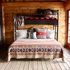 a bed in a room with wooden walls