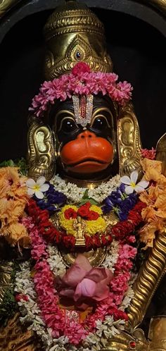 a statue of a monkey with flowers around it's neck