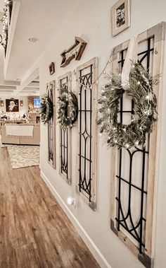 there are wreaths hanging on the wall next to each other in this room with wood floors and white walls