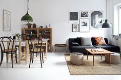 a living room filled with furniture next to a dining table and chairs in front of a window