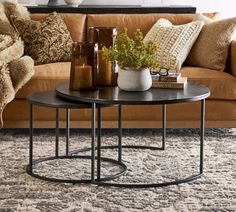 a living room with a couch, table and vases on the coffee table in front of it