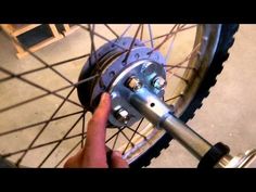 a person is holding the spokes of a bicycle wheel to adjust it's tire