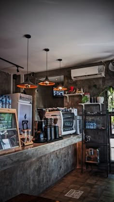 a coffee shop with various items on the counter and lights hanging from the ceiling above