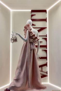 a mannequin dressed in a pink dress and matching shoes