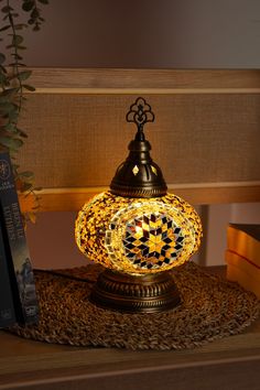 a lamp sitting on top of a table next to a book