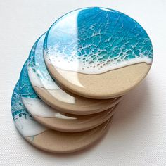 four blue and white plates stacked on top of each other in the shape of waves