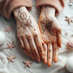 two hands decorated with hendi designs on top of a white sheet next to eggs