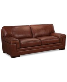 a brown leather couch sitting on top of a white floor