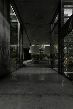 an empty room with large windows and floor to ceiling lighting in the center, surrounded by greenery