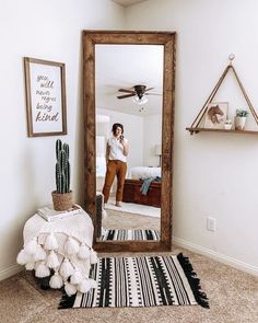 a woman is taking a selfie in the mirror while she stands by her bed